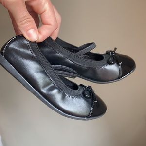 Children place black ballet flats